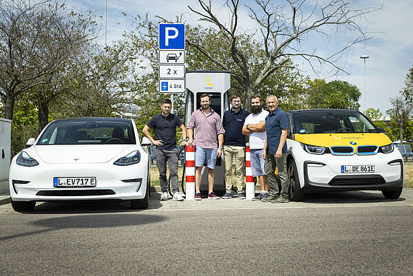 Vor der neuen Schnellladesäule am Paunsdorf Center stehen Adam Fiedler (Leipziger Stadtwerke), Viktor Wolff (Taubert Consulting), Benjamin Stollberg (Leipziger Stadtwerke), Martin Leutelt (HTWK Leipzig) und Prof. Dr.-Ing. Andreas Pretschner (HTWK Leipzig)