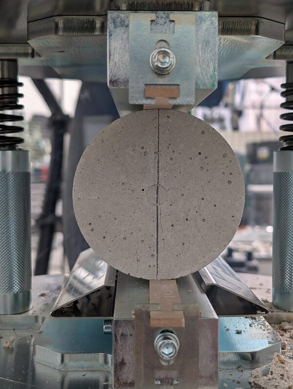 rundes Betonteil zwischen Metallkompresse/bei Verlinkung führt Link zur Projektwebsite