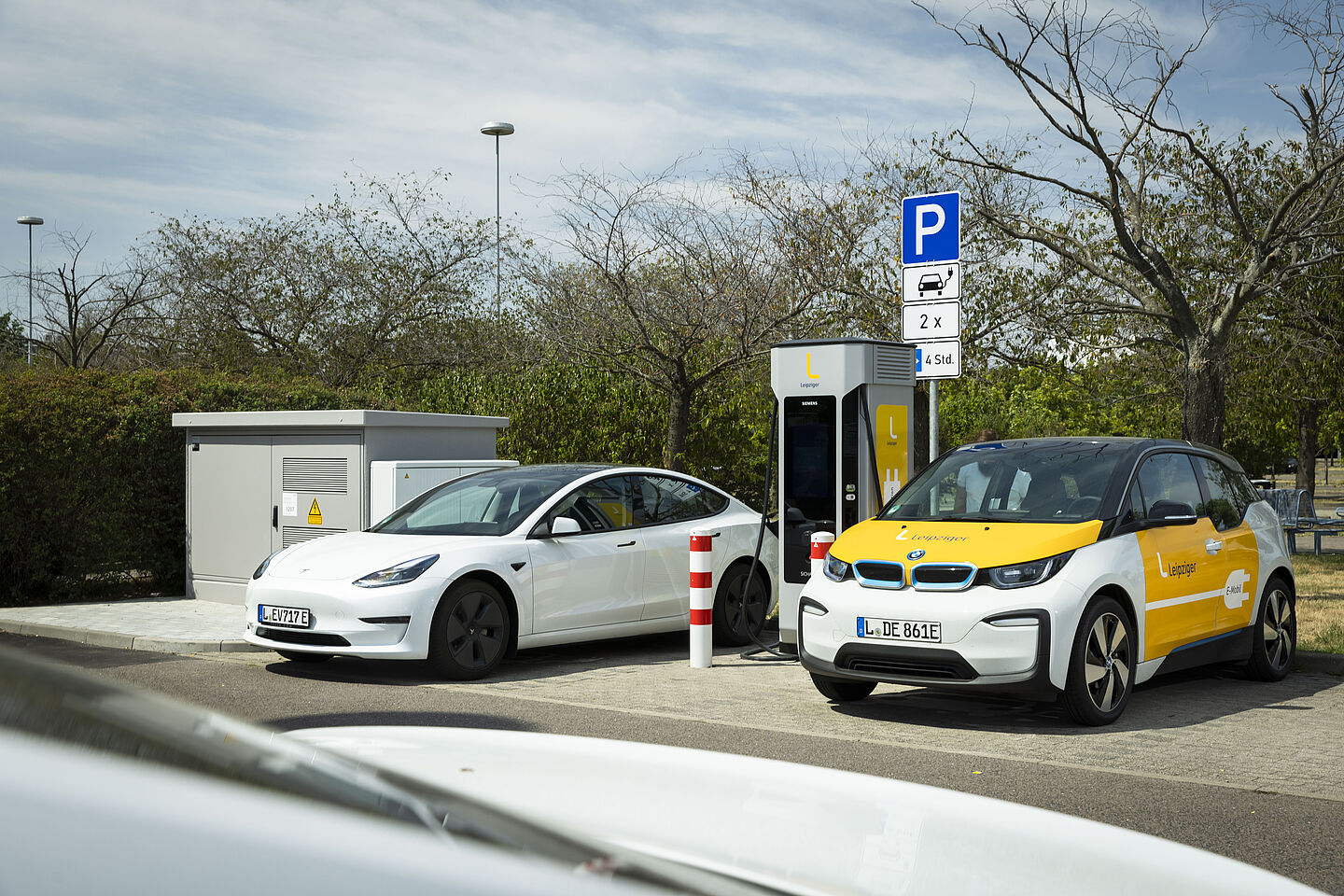 An der Schnellladesäule stehen zwei Elektroautos und laden.